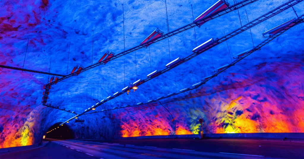 Laerdal Tunnel in Norway with colorful lights illuminating the interior.